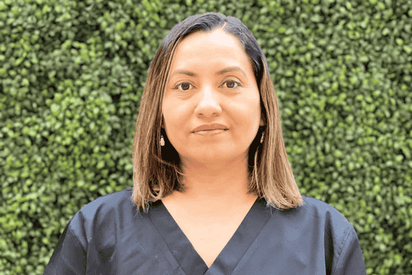 Isabel Cruz, owner of Natural Hands Massage Therapy Clinic, smiling warmly in a professional setting.